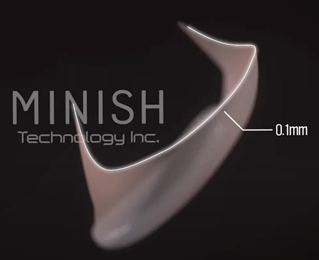 A side profile of a MINISH 0.1mm ultra-thin veneer highlighting its precision and minimal thickness.